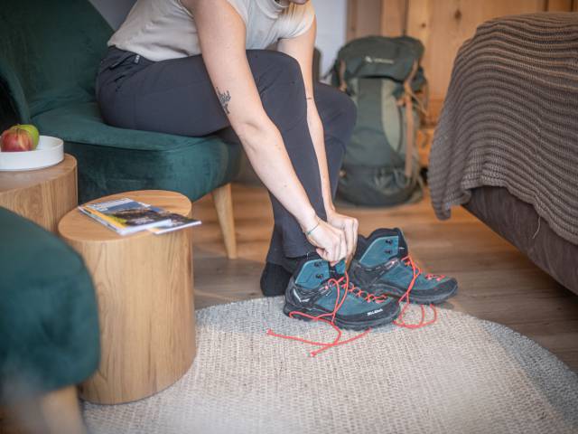 Frau zieht Wanderschuhe an